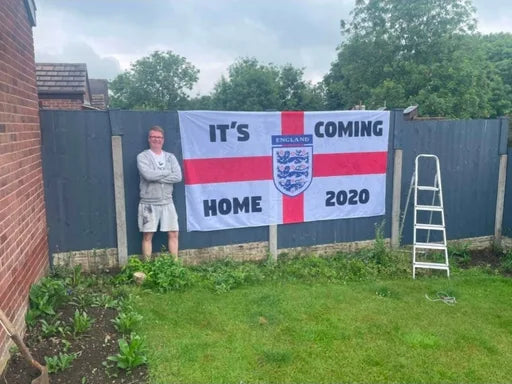 Supporter beside a large It’s Coming Home 2020 England flag
