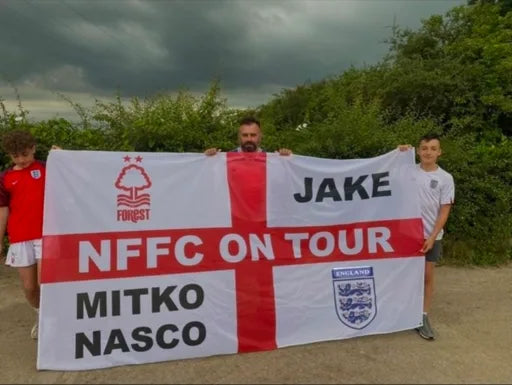 Supporters holding a personalised Nottingham Forest NFFC On Tour flag